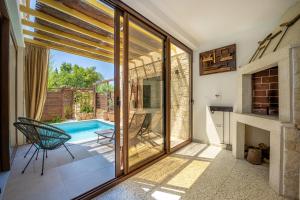 - un salon avec une piscine et des portes coulissantes en verre dans l'établissement Villa Nascosta, à Vodnjan