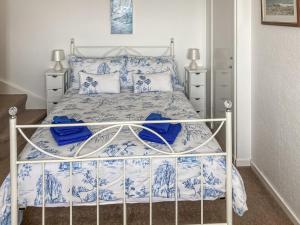 a bedroom with a bed with blue and white sheets and pillows at Cross Tides in Hilton of Cadboll