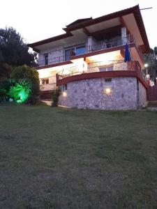 een groot huis met verlichting aan de zijkant van een tuin bij Villa Nestor in Platamonas