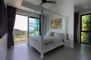 una camera con un letto bianco e una grande finestra di Villa La Moon Chaweng Noi 4BR a Ko Samui