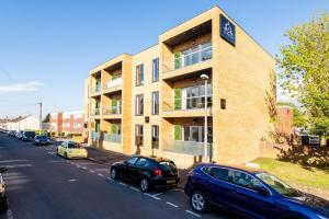 a building with cars parked on the side of a street at Elevate Your Stay - Luxury Apartments in Gillingham in Gillingham