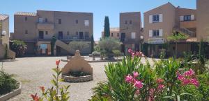 a courtyard with flowers and a statue in front of buildings at Le Duplex 4 Pers - 10 min des plages in Sainte-Croix-de-Verdon