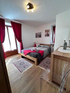 1 dormitorio con 1 cama con manta roja en Bilocale Centro Pré-Saint-Didier, en Pré-Saint-Didier