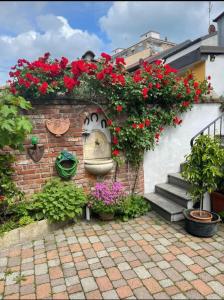 a brick wall with flowers and a statue of a face at Maison Di Gugli in Brandizzo