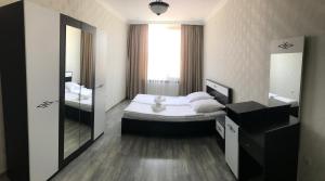 una piccola camera da letto con un letto e uno specchio di Friendly House a Akhaltsikhe