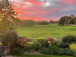 a garden with a field in the background with a sunset at Church View in Weston Subedge