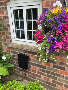 a window with flowers on a brick wall at Church View in Weston Subedge +9 photos