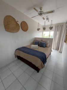 a bedroom with a bed and a ceiling fan at Het Kadootje - Southbroom's little gift - 6 sleeper 3 bedroom apartment in Southbroom