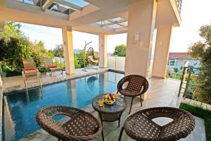 un patio con sillas y una mesa junto a la piscina en Villa With a Private Heated Pool, Jacuzzi, Overlooking Spectacular Views Of The Sea en Kas