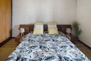 uma cama num quarto com duas almofadas em Alojamento do Rosário em Lagoa