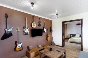a room with a bunch of guitars on the wall at Alojamento do Rosário in Lagoa