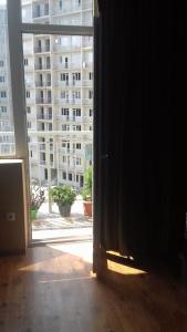 an open door to a large window with a view of a building at One bedroom apartment for rent in Tbilisi City