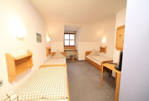 ein Krankenhauszimmer mit 2 Betten und einem TV in der Unterkunft Gasthof zum Bayerischen in Greding
