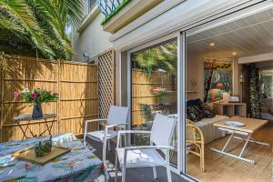 eine Terrasse mit Stühlen, einem Tisch und einem Sofa in der Unterkunft Sous les Palmiers - Charmant Appartement avec terrasse in Vannes