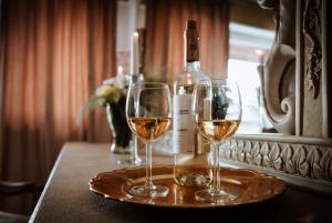 two glasses of wine on a table with a bottle of wine at Targowski Dwór Mazury in Dźwierzuty +100 photos