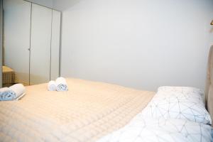1 dormitorio con 1 cama con toallas en HARMONY Stay APARTAMENTAI, en Telšiai