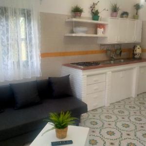 a living room with a couch and a kitchen at Hotel & Resort Lunatenuta in Mondragone