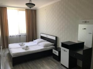 Schlafzimmer mit einem Bett mit weißer Bettwäsche und einem Fenster in der Unterkunft Friendly House in Achalziche
