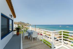 a balcony with a table and chairs and the beach at George Apartments Stegna in Archangelos
