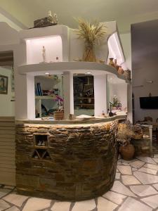 an outdoor bar with a stone fireplace in a room at Afrodite Hotel in Tinos