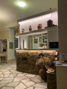 a living room with a brick fireplace with a mirror at Afrodite Hotel in Tinos