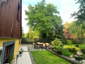 a patio with a table and chairs in a garden at Chatka Baby Jagi in Ściegny