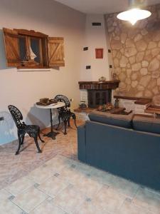 sala de estar con mesa, sillas y chimenea en Villa Nestor en Platamonas