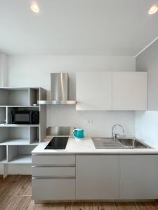 a white kitchen with white cabinets and a sink at M14 RESIDENZA BASSANELLO in Padova