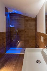 a bathroom with a shower with blue lighting at M14 RESIDENZA BASSANELLO in Padova