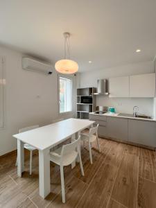a white kitchen with a white table and chairs at M14 RESIDENZA BASSANELLO in Padova +50 photos