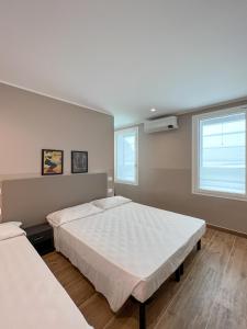a bedroom with two beds and a window at M14 RESIDENZA BASSANELLO in Padova
