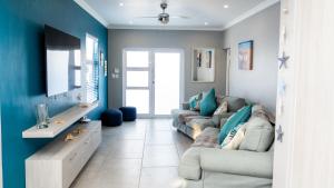 sala de estar con 2 sofás y paredes azules en Starfish Cottage, Langebaan, en Langebaan