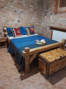 una cama de madera con sábanas azules y almohadas. en Villa Nestor en Platamonas