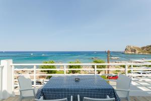 アルハンゲロスにあるGeorge Apartments Stegnaのビーチ付きのバルコニー(テーブル、椅子付)