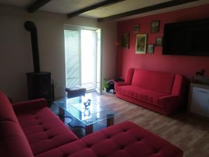 a living room with two red couches and a glass table at Apartmány u koní 