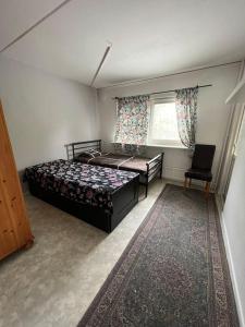 ein Schlafzimmer mit einem Bett, einem Stuhl und einem Fenster in der Unterkunft Nice room with balcony in Göteborg