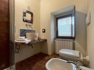 uma casa de banho com um WC, um lavatório e uma janela em Terra della Baronia em Santo Stefano di Sessanio