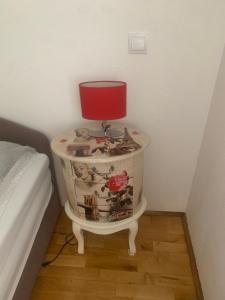 a red lamp on a table next to a bed at Apartman S & S in Makarska
