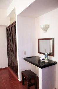a vanity in a room with a mirror and a stool at Suites Plaza del Rio - Family Hotel Malec&oacute;n Centro in Puerto Vallarta