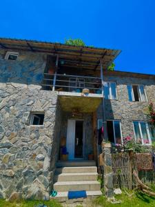 une maison en pierre avec des escaliers menant à la porte. dans l'établissement tamila's guesthause, à Mestia