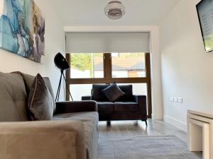 ein Wohnzimmer mit einem Sofa und einem Fenster in der Unterkunft Spacious 3 bed 3 bath Duplex Apartment - 18 mins from Central London - Sleeps 8 in Watford