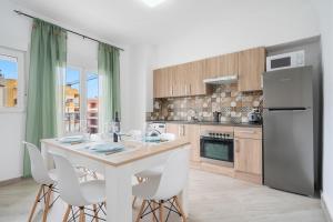 a kitchen with a table with white chairs and a refrigerator at Cambrils Turistic 3b in Cambrils