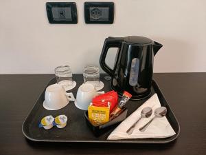 a black tray with a tea pot on a table at Hotel Villa Pannonia in Venice-Lido