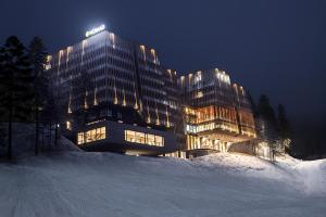 别拉什尼察Hotel Nomad的一座大建筑物,在晚上下雪