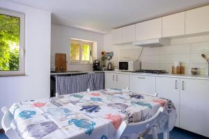 eine Küche mit einem Tisch und eine Küche mit weißen Schränken in der Unterkunft Domus Vini in San Giovanni la Punta