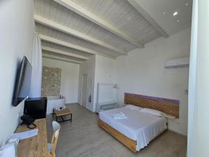 a bedroom with a bed and a flat screen tv at Luxury Pool Suites - Città Bianca in Pescara