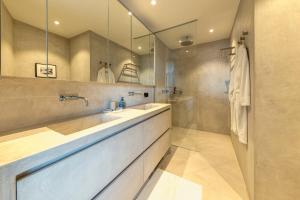 a bathroom with two sinks and a large mirror at Triplex penthouse in the city center in Brussels