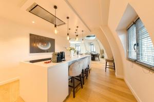 una cucina con bancone e un bar con sgabelli di Triplex penthouse in the city center a Bruxelles