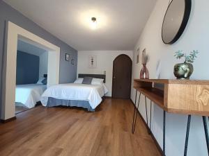 1 Schlafzimmer mit 2 Betten und einem Wandspiegel in der Unterkunft MANTRA- Zacatlán in Zacatlán