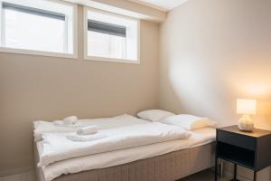 1 dormitorio con 1 cama con sábanas blancas y ventana en Nordic Nights: 3BR with Balcony, en Bergen